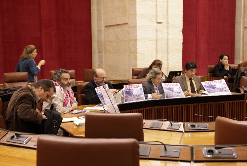 Los diputados del Grupo IULV-CA mostraron en el Pleno carteles de rechazo a la violencia con el pueblo saharaui