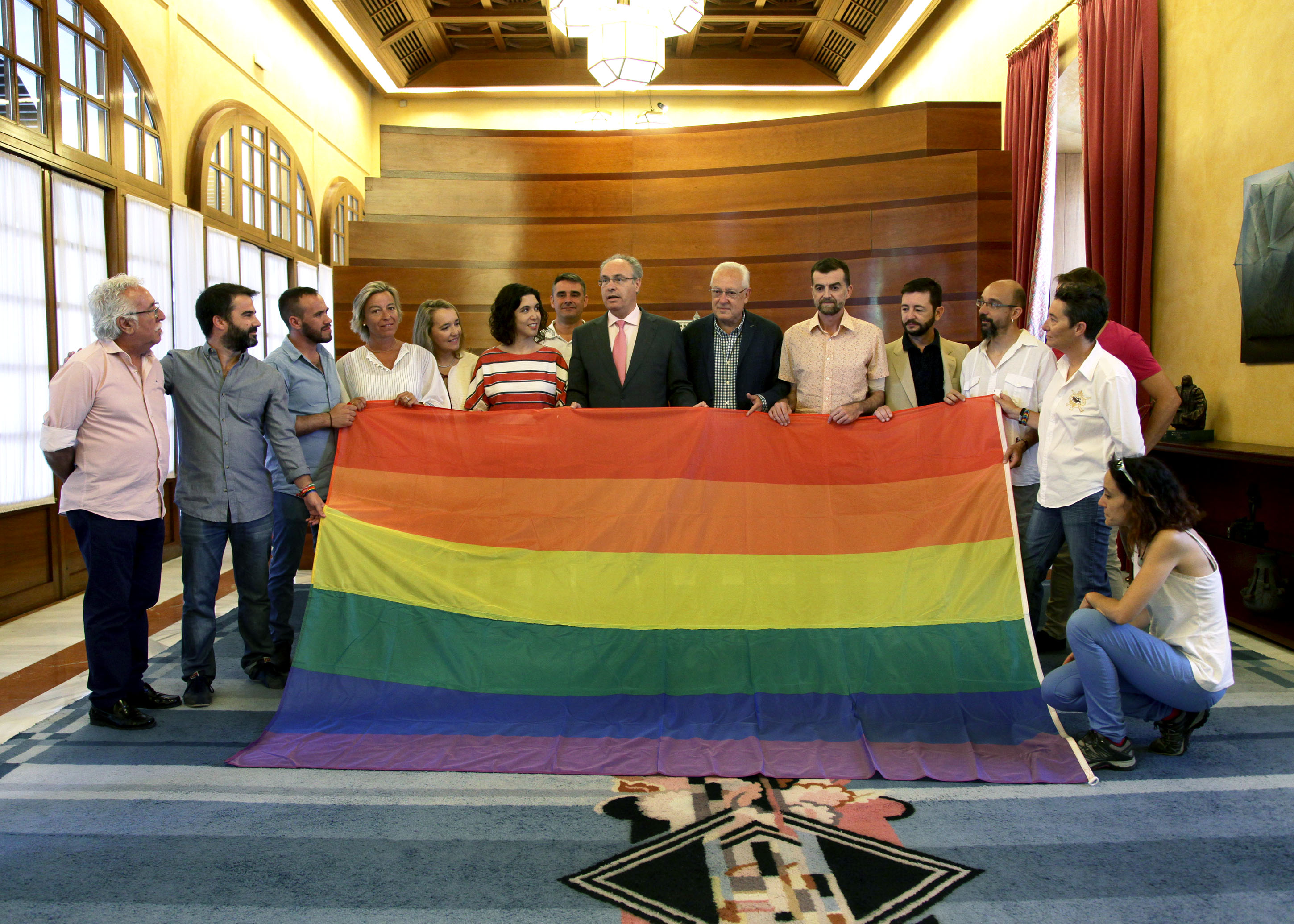 El presidente del Parlamento y diputados de los cinco grupos parlamentarios posan con la bandera de la diversidad cedida por el colectivo LGTBI