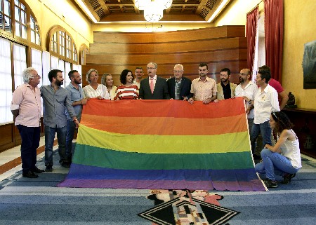 El presidente del Parlamento y diputados de los cinco grupos parlamentarios posan con la bandera de la diversidad cedida por el colectivo LGTBI