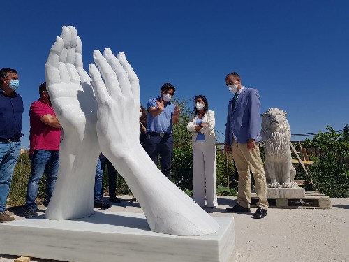 La presidenta del Parlamento, ante la escultura en homenaje a los sanitarios creada por AEMA 