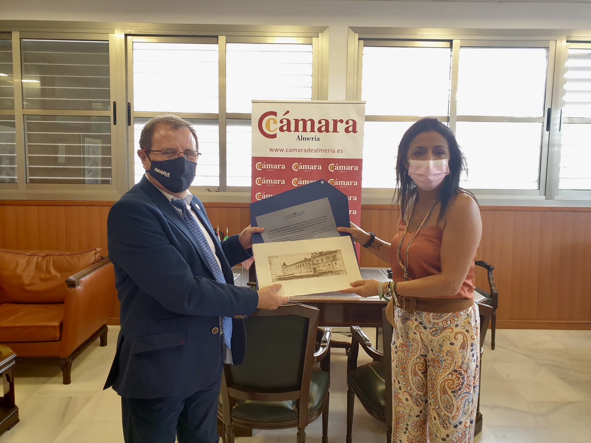 La presidenta del Parlamento de Andaluca, Marta Bosquet, le entrega un grabado de la sede autonmica a la Cmara de Comercio de Almera