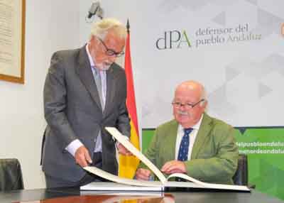  El presidente del Parlamento de Andalucía, Jesús Aguirre, firma el libro de honor de la institución del Defensor del Pueblo Andaluz en presencia d