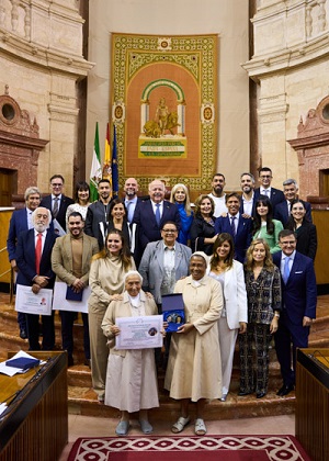    Los galardonados por Escuela Cultura de Paz posan tras el acto con el presidente del Parlamento y la consejera de Desarrollo Educativo