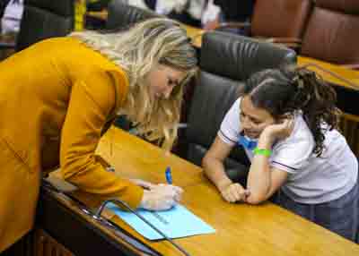  Ana Mestre, vicepresidenta primera del Parlamento, habla con una de las participantes en el pleno 