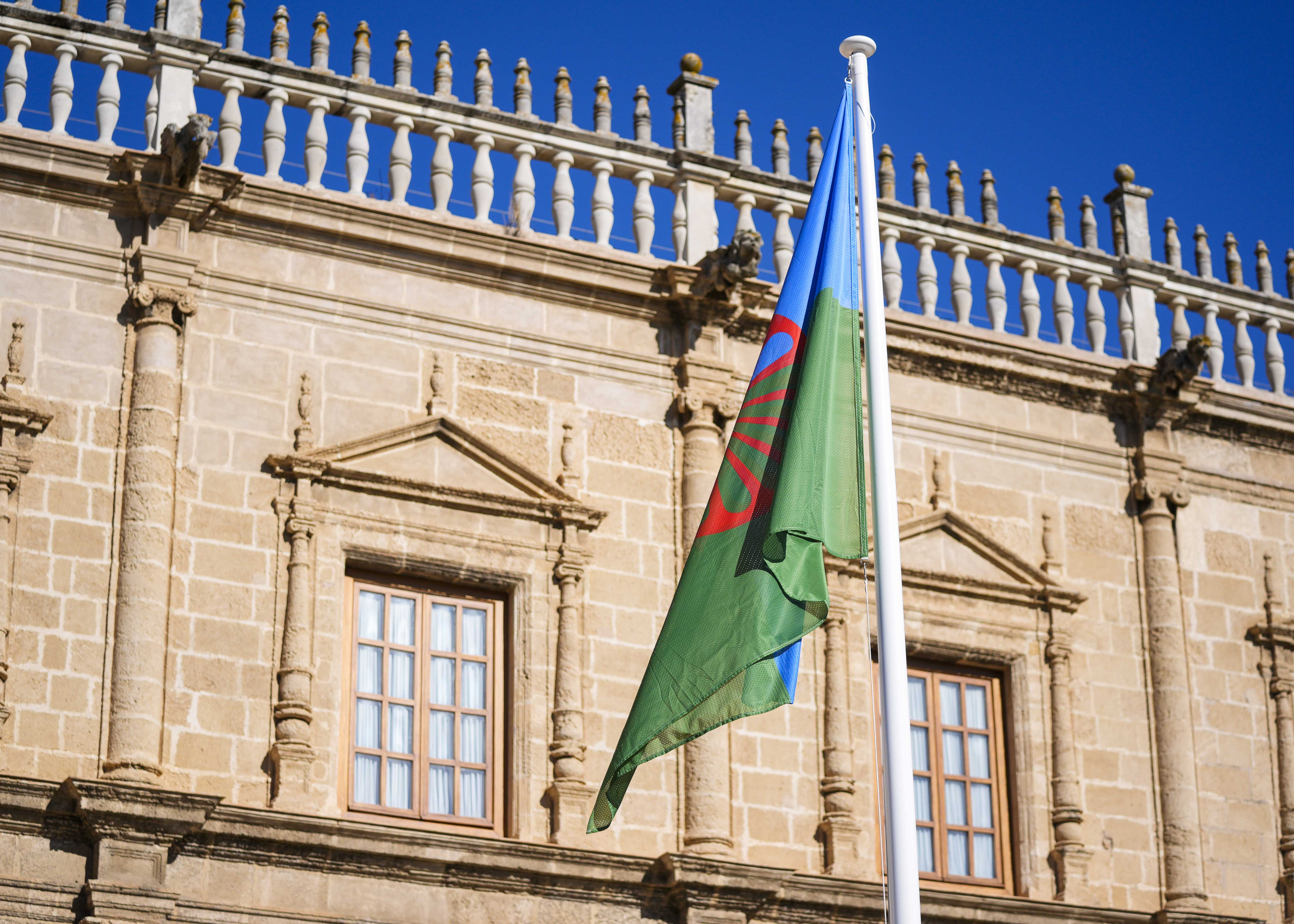  La bandera gitana ondea en la fachada del Parlamento