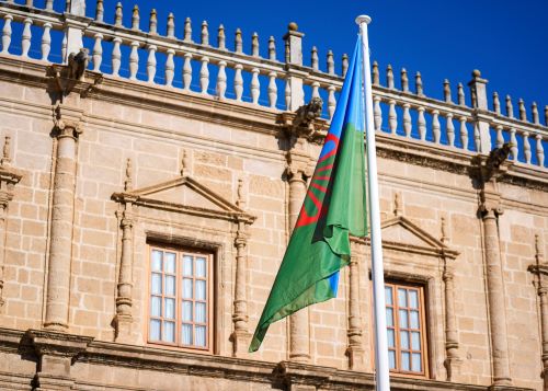  La bandera gitana ondea en la fachada del Parlamento