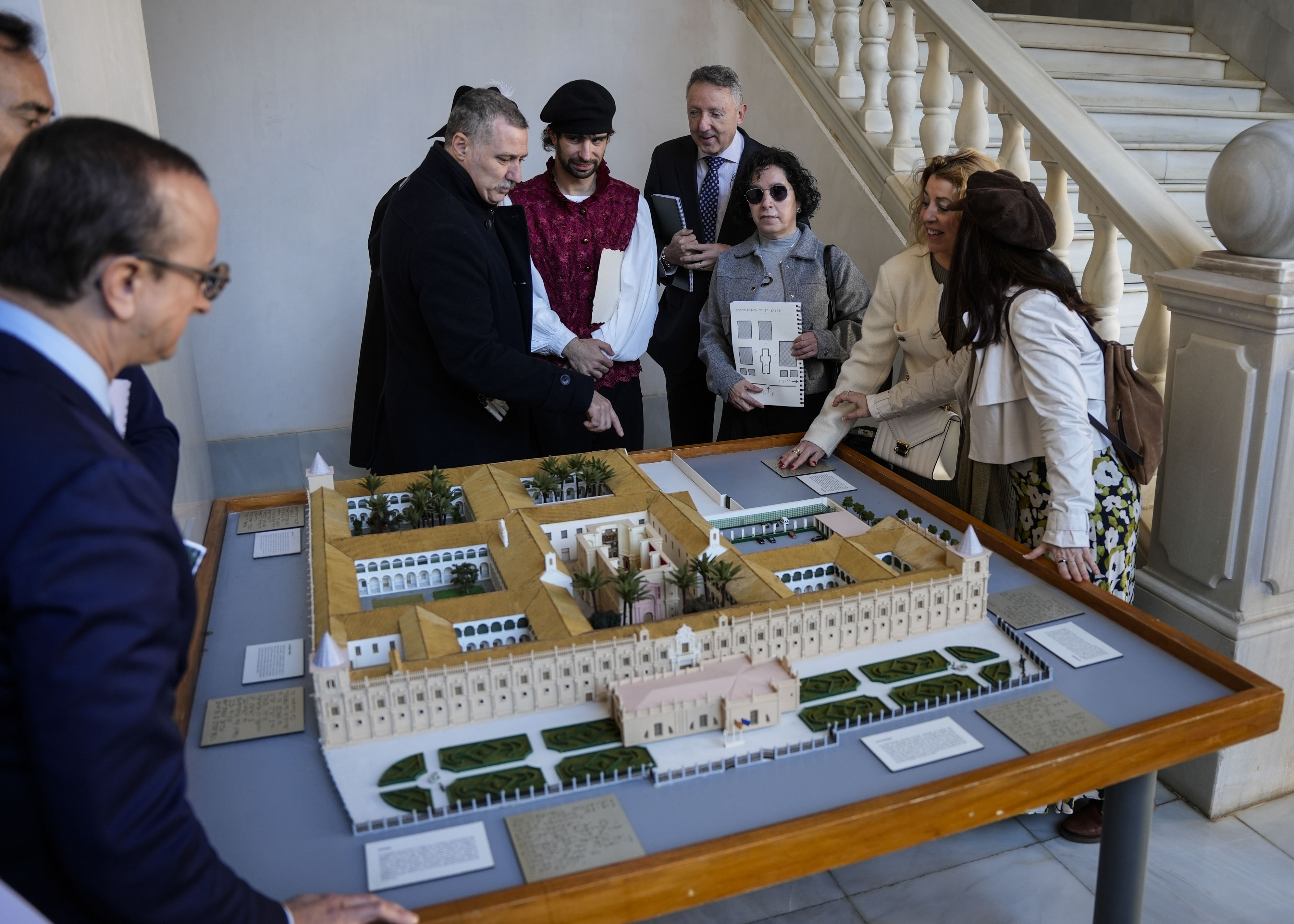   El grupo de la ONCE examina la maqueta del edificio