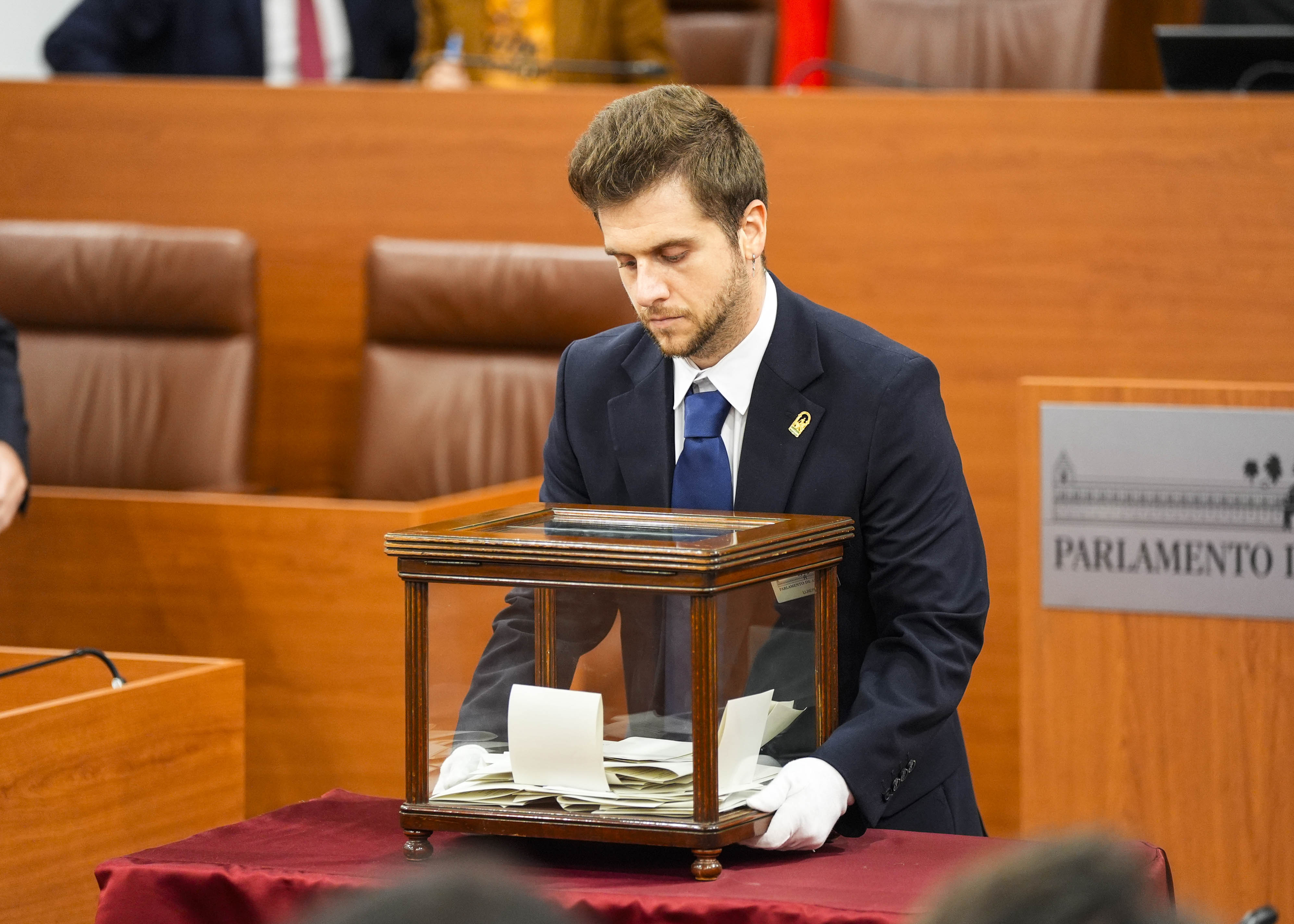 Un ujier procede a retirar la urna tras la votaci�n de los diputados 
