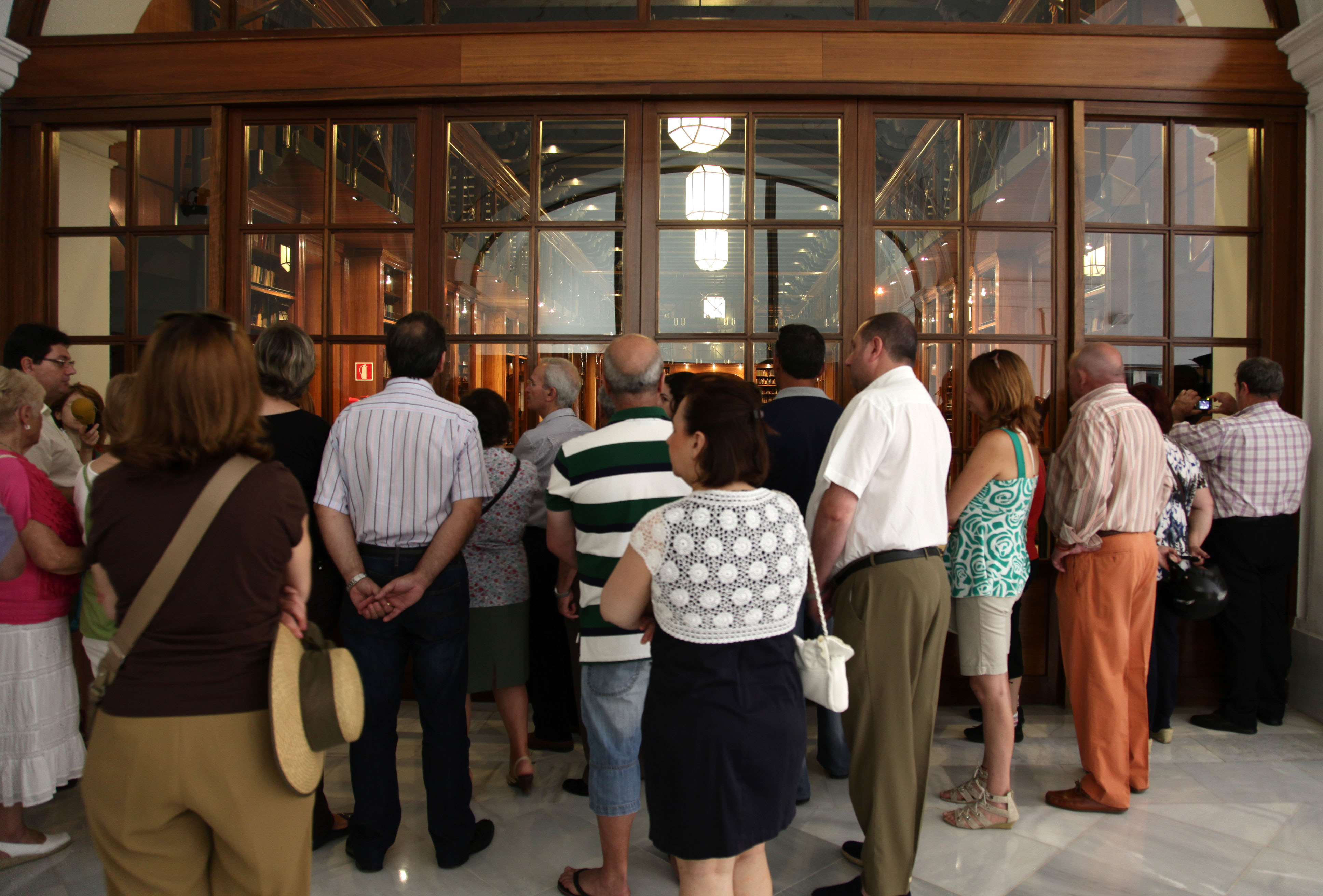 Un grupo de ciudadanos contempla la biblioteca del Parlamento durante el recorrido de la visita en la Jornada de Puertas Abiertas con motivo del XXX Aniversario del Parlamento