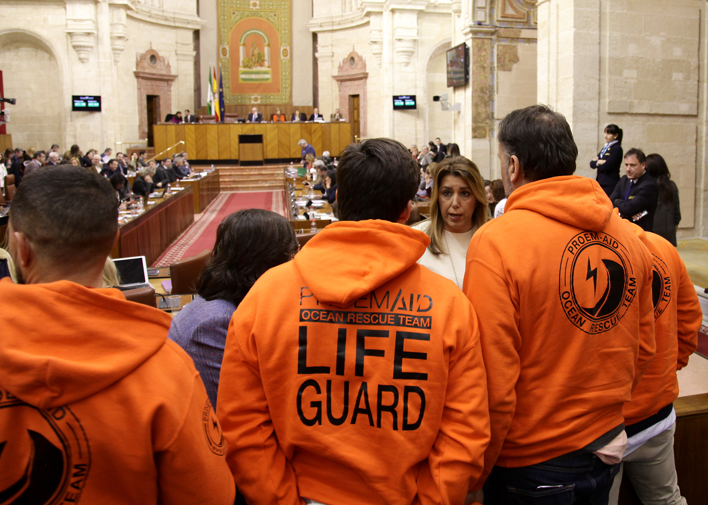 Susana D�az saluda a los componentes de la ONG PROEMAID invitados en la tribuna de p�blico del Parlamento