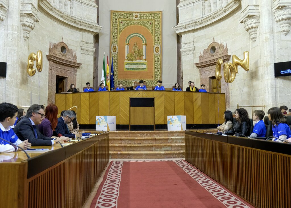  La Mesa del Parlamento compuesta por los nios, nias y adolescentes que han participado en el Pleno Infantil. En la bancada izquierda diputados de los grupos parlamentarios y en la de la derecha la presidenta Bosquet y la consejera Ruiz  