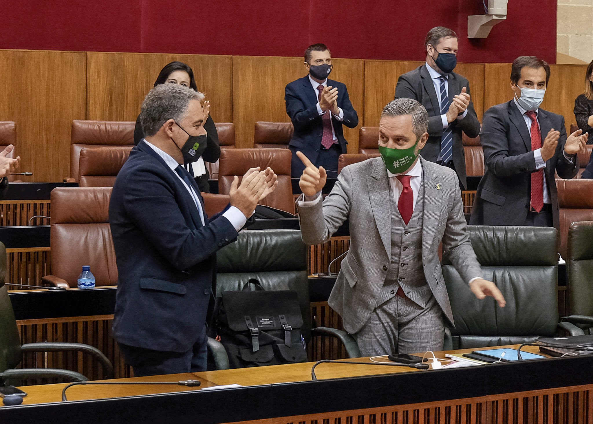 Juan Bravo, consejero de Hacienda, hace un simptico gesto al consejero de la Presidencia, Elas Bendodo 